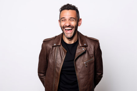 Portrait of a happy young man in leather jacket on white backgroundの素材