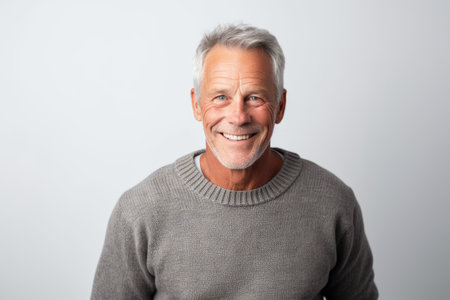 Portrait of a happy senior man with gray hair smiling at the camera.の素材