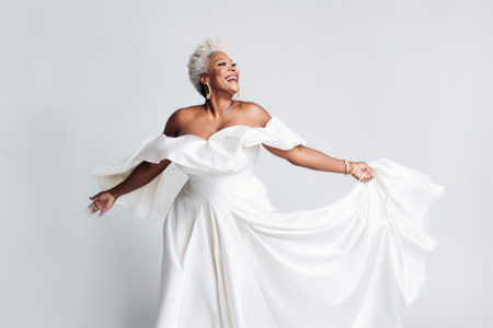 Portrait of a beautiful woman in white wedding dress posing isolated on a white backgroundの素材