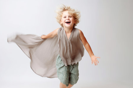 Portrait of a happy little boy jumping and laughing isolated on a white backgroundの素材