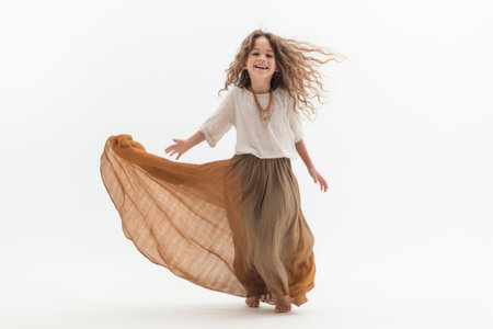 Beautiful little girl with long hair in a long skirt on a white backgroundの素材