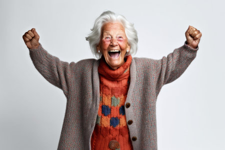 Portrait of a happy senior woman celebrating success isolated on a white backgroundの素材