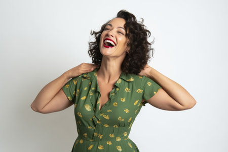 Portrait of a beautiful young woman laughing with her hands on her neckの素材