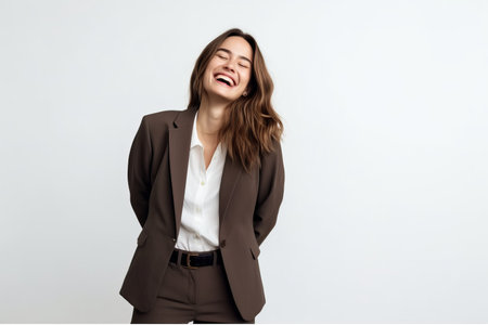 Portrait of a happy young business woman laughing over white background.の素材