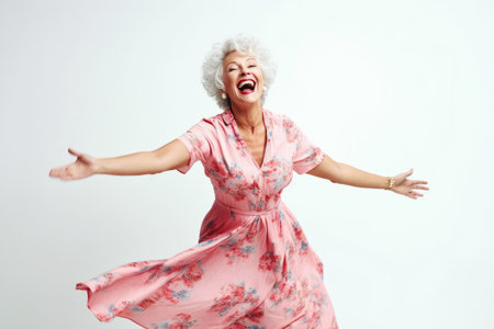 Portrait of a happy senior woman dancing isolated on a white backgroundの素材