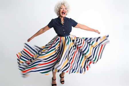 Full length portrait of a happy senior woman dancing on a white backgroundの素材