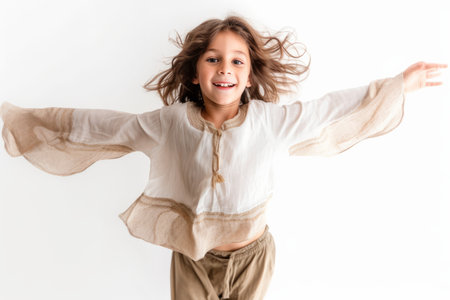 Little girl with long hair in a white shirt on a white backgroundの素材