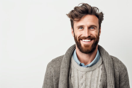Portrait of a handsome young man in sweater smiling at camera over white backgroundの素材
