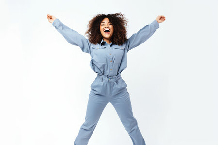 happy african american woman in overalls jumping isolated on whiteの素材