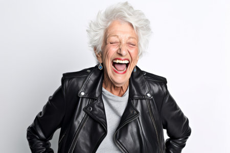 Portrait of a happy senior woman in leather jacket on white backgroundの素材