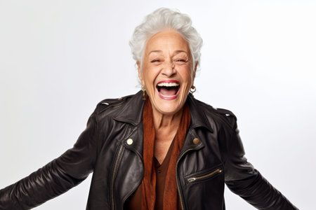 Portrait of a happy senior woman laughing against a white background.の素材