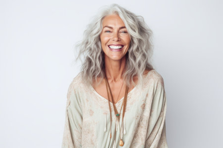 Portrait of happy mature woman with gray hair smiling at camera.の素材