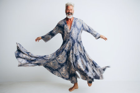Elderly man in a blue dress dancing on a white backgroundの素材