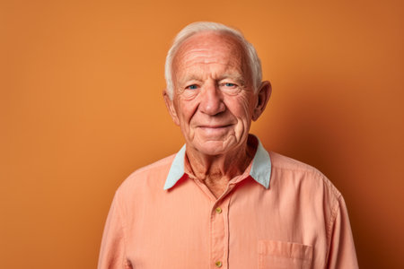 Portrait of a senior man in a shirt on an orange backgroundの素材