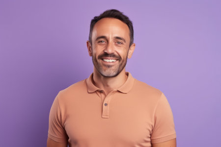 Portrait of a smiling man looking at the camera while standing against purple backgroundの素材