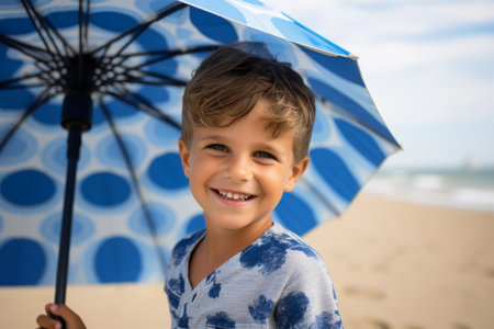 Portrait of smiling boy with umbrella on the beach in the summerの素材