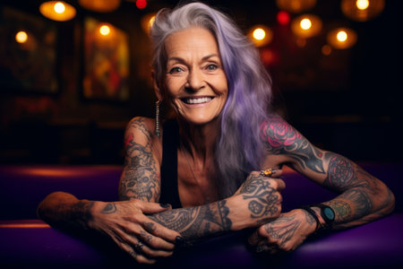 Portrait of a happy senior woman with tattoos on her arms sitting in a nightclub.の素材