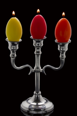 Three easter candles in the form of eggs in a candelabrum の写真素材