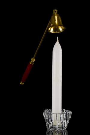 Candle in glass candlestick and candle snuffer on black backgroundの写真素材