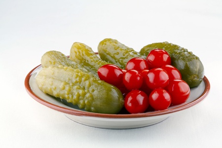 Dish with cucumbers and ripe tomatoes pickled at home with spicesの写真素材