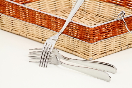 Forks and a basket of multicolored straws on a light backgroundの写真素材