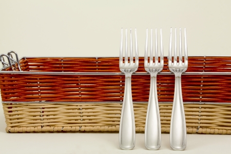 Forks and a basket of multicolored straws on a light backgroundの写真素材