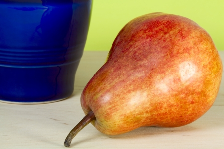 Pear and blue pitcher on a yellow backgroundの写真素材