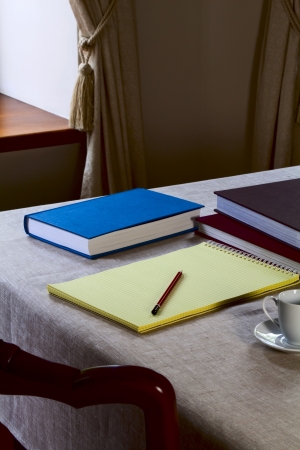Notebook on the table with a pencil and booksの写真素材