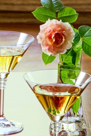 Rose in a glass vase and white wine in glassesの写真素材