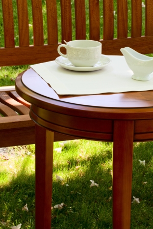 On the table in the garden a cup for tea and milk jugの写真素材