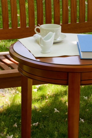 On the table in the garden a cup for tea and milk jugの写真素材
