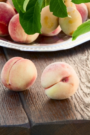 Ripe goldish velvety peaches and yellow plumsの写真素材