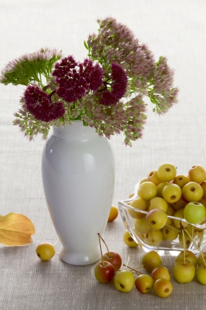 Wild apples in a glass vase and autumn flowersの写真素材