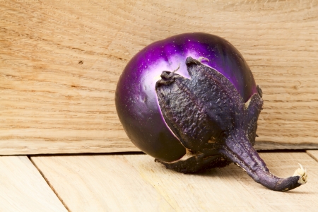 One rounded ripe eggplant on a wooden backgroundの写真素材