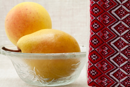 Ripe pears in a glass bowl and towel with ornamentの写真素材