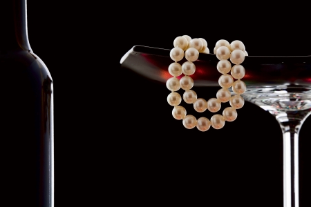 Pearl necklace in a glass vase on a black backgroundの写真素材