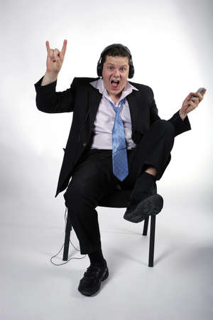Young businessman having fun at work while listening to music. Studio shotの写真素材