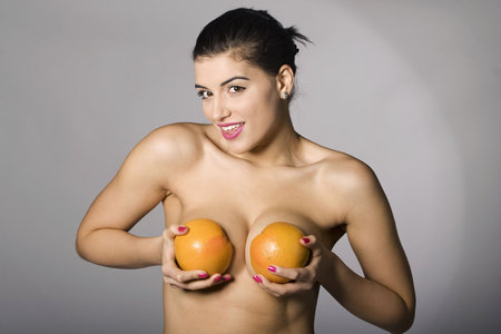 Portrait of a beautiful woman with grapefruit. Studio shots. Part of a series.の写真素材