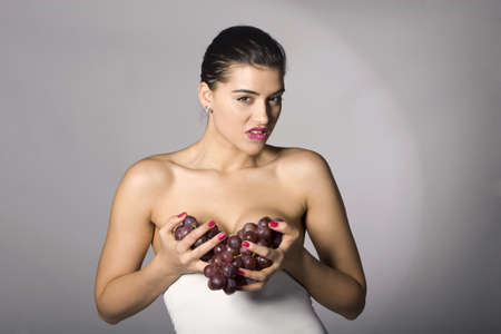 Part of photo series . Woman with red grapes. Studio shotsの写真素材