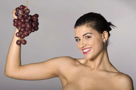 Part of photo series . Woman with red grapes. Studio shotsの写真素材