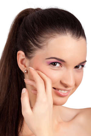 Closeup portrait of a pretty young woman smiling and touching her face. High resolution image taken in studio. Isolated on pure white background with copy space for your ad.の写真素材