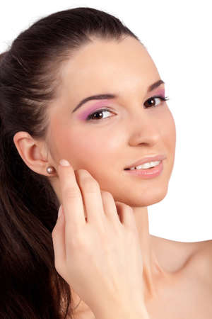 Closeup portrait of a pretty young woman smiling and touching her face. High resolution image taken in studio. Isolated on pure white background with copy space for your ad.の写真素材