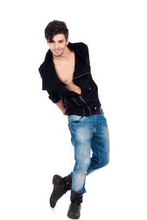 Handsome happy young fashion model posing wearing jeans, boots and a black jacket. Isolated on white background. Studio vertical image.の写真素材