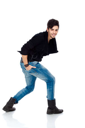 Handsome happy young fashion model wearing jeans, boots and a black jacket. Isolated on white background. Studio vertical image.の写真素材