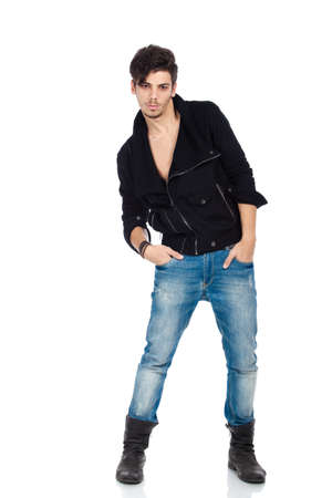 Attractive young fashion model wearing jeans, boots and a black jacket. Isolated on white background. Studio vertical image.の写真素材