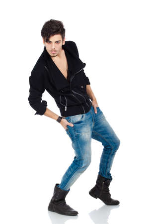 Cool young fashion model wearing jeans, boots and a black jacket. Isolated on white background. Studio vertical image.の写真素材