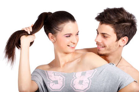 Happy young couple flirting and playing, smiling. Isolated on white background. High resolution studio image.の写真素材