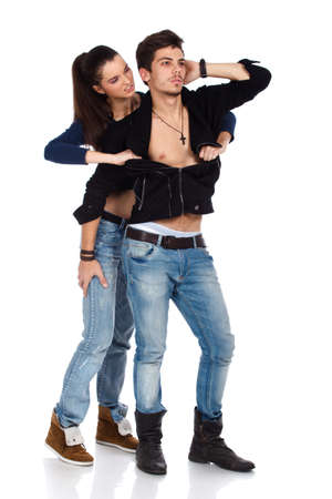 Passionate young couple. Sexy woman ripping her boyfriend shirt off. Isolated on white background. High resolution studio image. Full bodyの写真素材