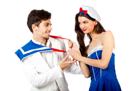 Happy young couple playing in sailor uniform. Isolated on white background. High resolution studio imageの写真素材