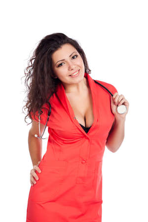 Sexy happy young nurse or medical woman doctor with big breasts, wearing tangerine tango orange uniform dress , smiling, holding stethoscope. Isolated on white background with text space. High resolution studio image.の写真素材